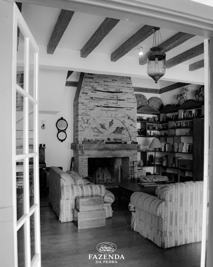 Sala com lareira e vigas de madeira, em preto e branco